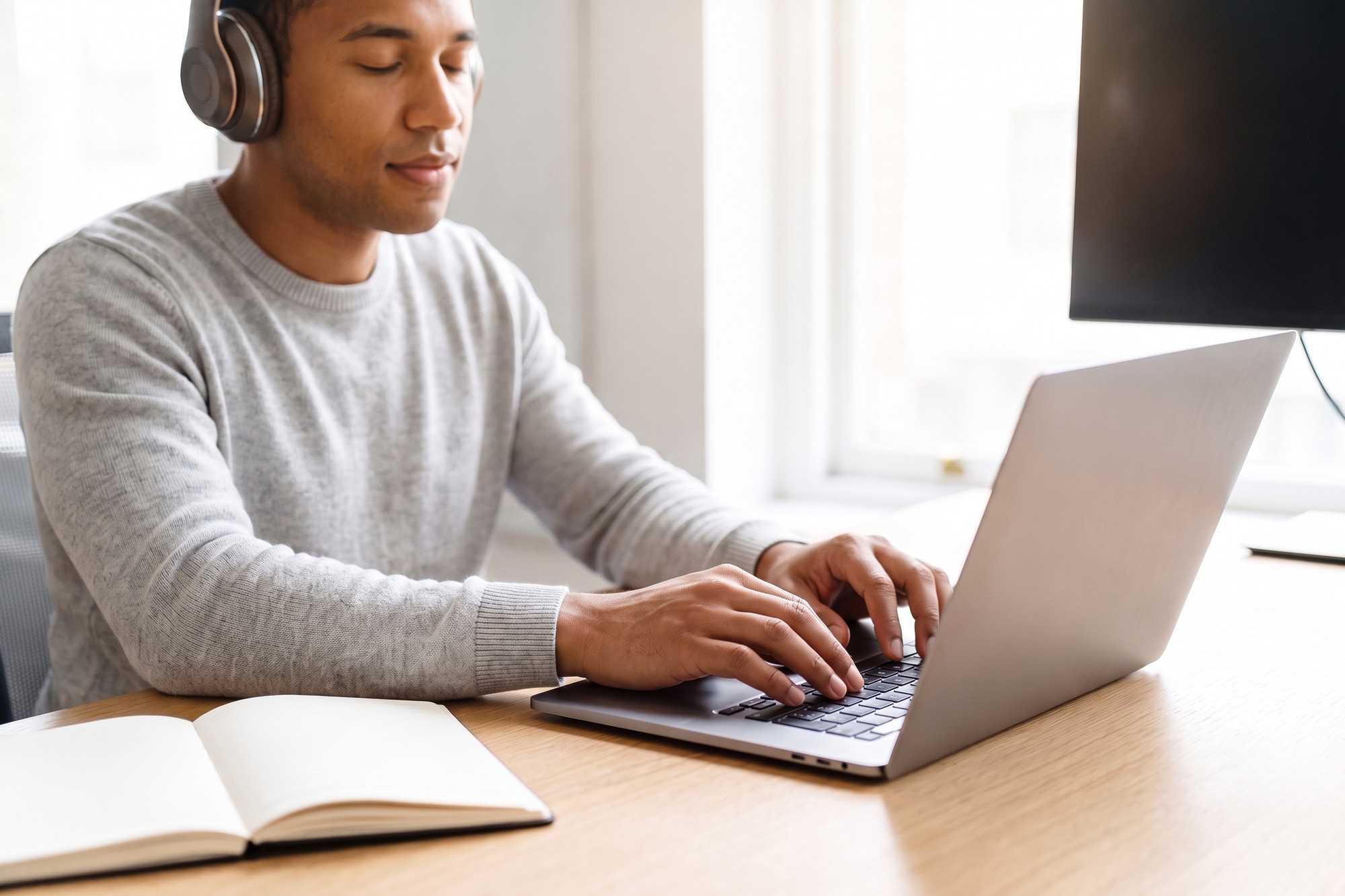 Developer in headphones testing website accessibility with a screen reader and keyboard